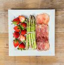 Green asparagus with ham and strawberries